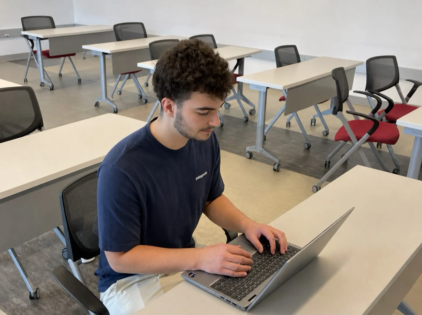 Evan Kuczer working on a laptop in a classroom